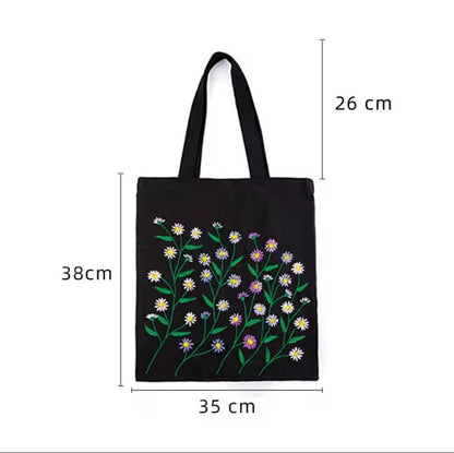 Black canvas tote bag with embroidered daisy stems and size diagram showing 35 cm width and 38 cm body height.
