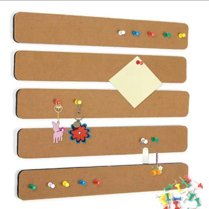 Five beige felt wall strips with coloured pushpins, a note and keychain charms hanging from pins.