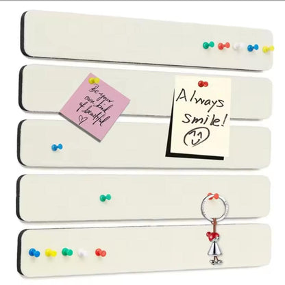Five white felt pinboard strips with coloured pushpins, handwritten notes and a hanging charm.