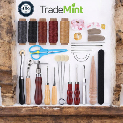Thirty-piece leathercraft tool kit laid out with waxed thread, stitching needles, awls, groover, scissors and other tools.