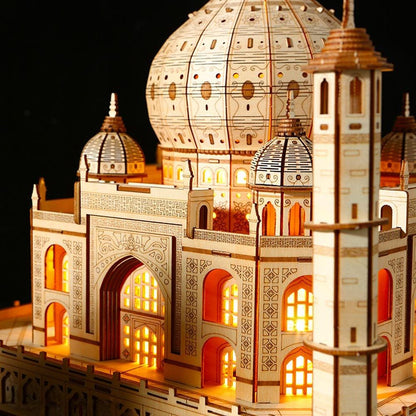 Wooden Taj Mahal puzzle model side view with glowing windows, large dome and tall minaret.