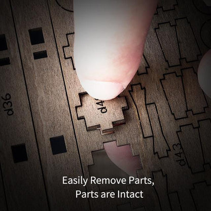 Finger pressing a small laser-cut wooden part out of a puzzle sheet.