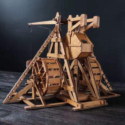 Rear angled view of medieval trebuchet 3D wooden puzzle with large wheels and support beams.