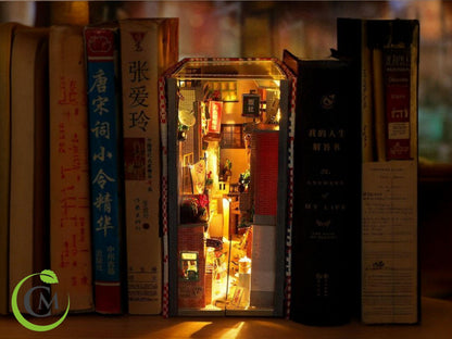 Retro Chinese street book nook miniature glowing between books on a shelf.