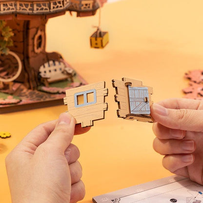 Hands assembling small wooden window and door parts for Sakura Tree House model.