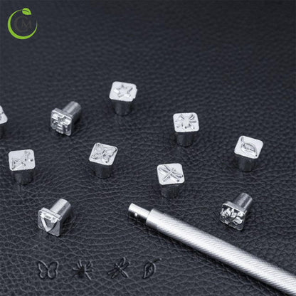 Metal leather embossing stamp set with silver handle and decorative mini stamps on black leather.