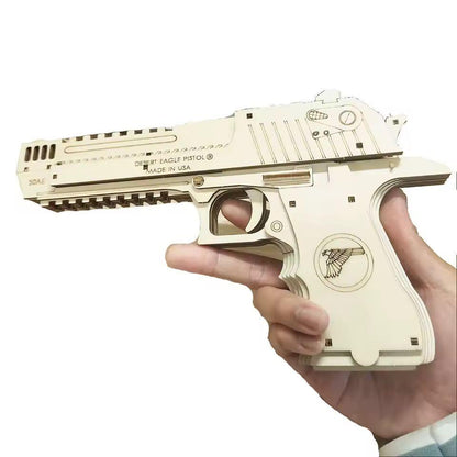 Hand holding pale wooden elastic band launcher puzzle with carved body and moving trigger.