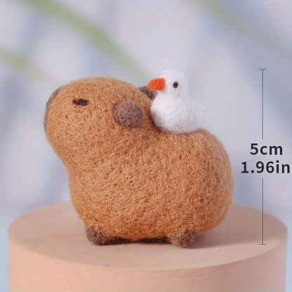 Brown needle-felted capybara and white bird miniature shown with an approximate 5 cm height.