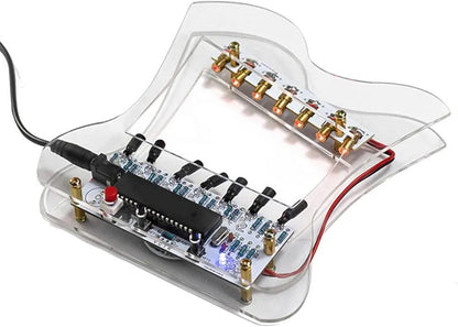 Angled overhead view of transparent laser harp soldering project with mounted circuit board and brass emitters.