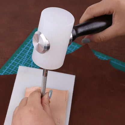 Hand using black-handled white nylon mallet to strike a leather stamping tool over tan leather.