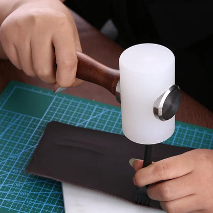 Hand striking a leathercraft pricking tool using white nylon mallet on dark leather over cutting mat.