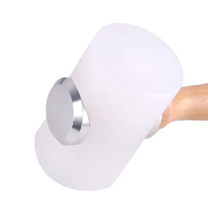 Close-up of white nylon craft mallet head with polished metal side cap and light wood handle.
