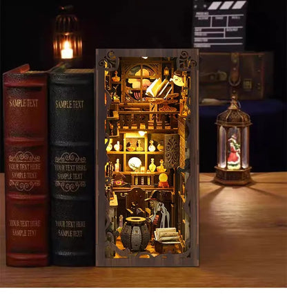 Front view of illuminated Magic Night miniature book nook between vintage books and lantern.